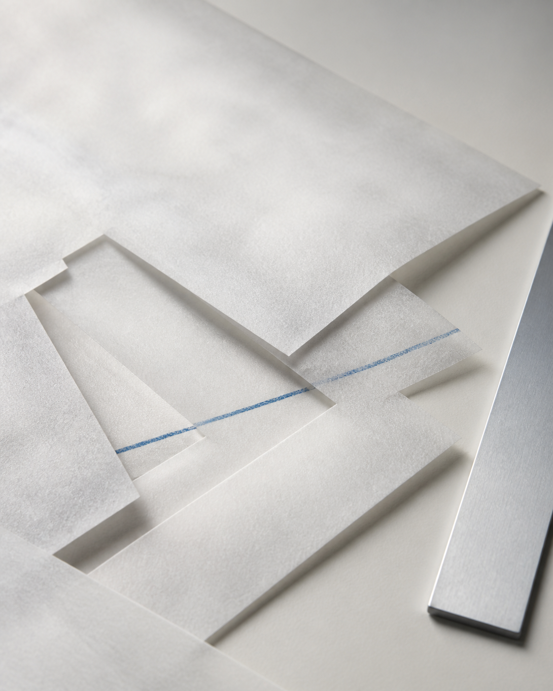 Capas de papel translúcido atravesadas por una línea azul